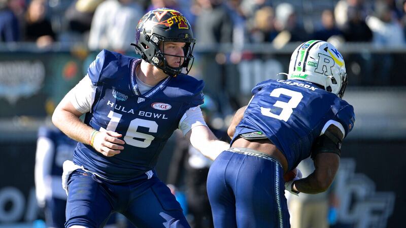 Team Aina quarterback Chase Brice (16), of Appalachian State, hands off the ball to running...