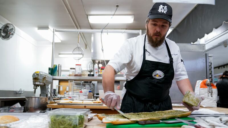 Chef Josh Gjersand prepares a sandwich for Mount Diablo High School students to try during a...