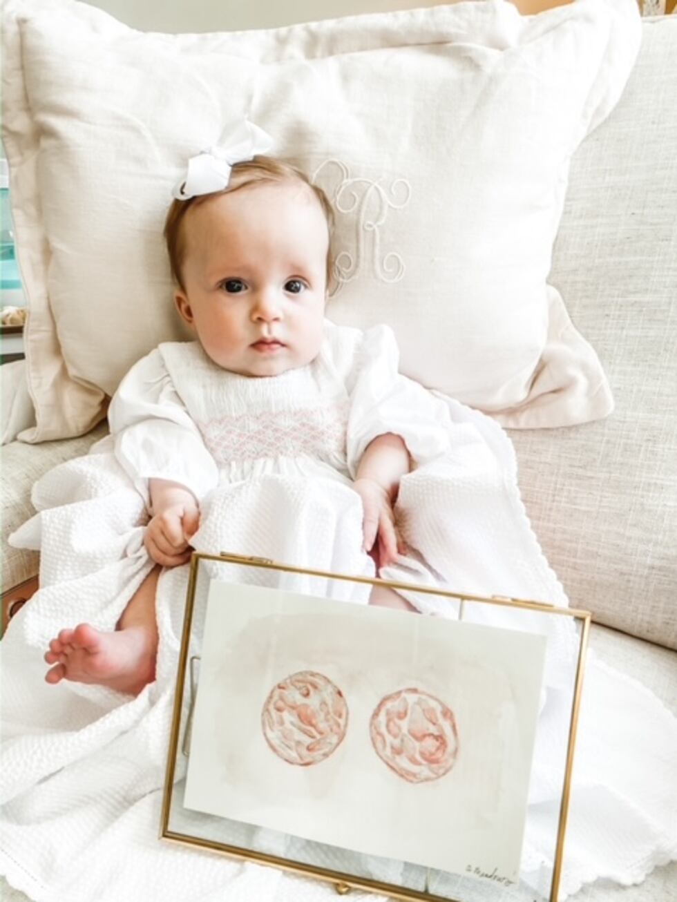 Lily Ruth poses next to a picture of her as a small cell.