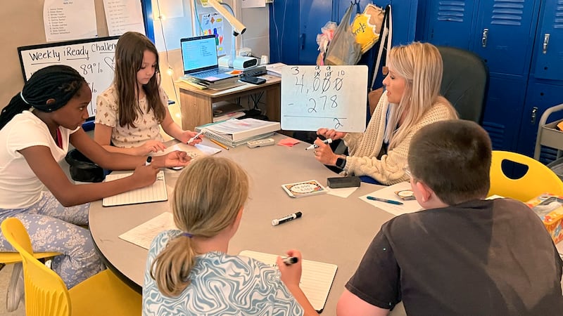 Piedmont Elementary School math teacher Cassie Holbrooks helps a small group of fourth-grade...