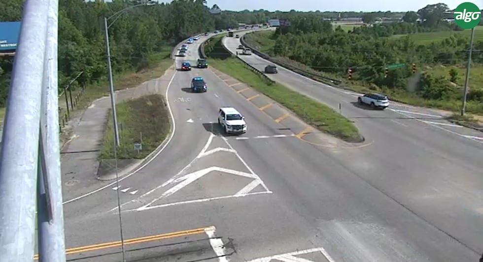A law enforcement motorcade carrying the body of the late Cpl. Desmond Bailey travels down...