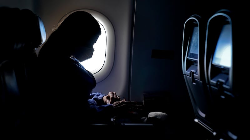 FILE - In this Wednesday, Feb. 3, 2021, file photo, a passenger wears a face mask she travels...