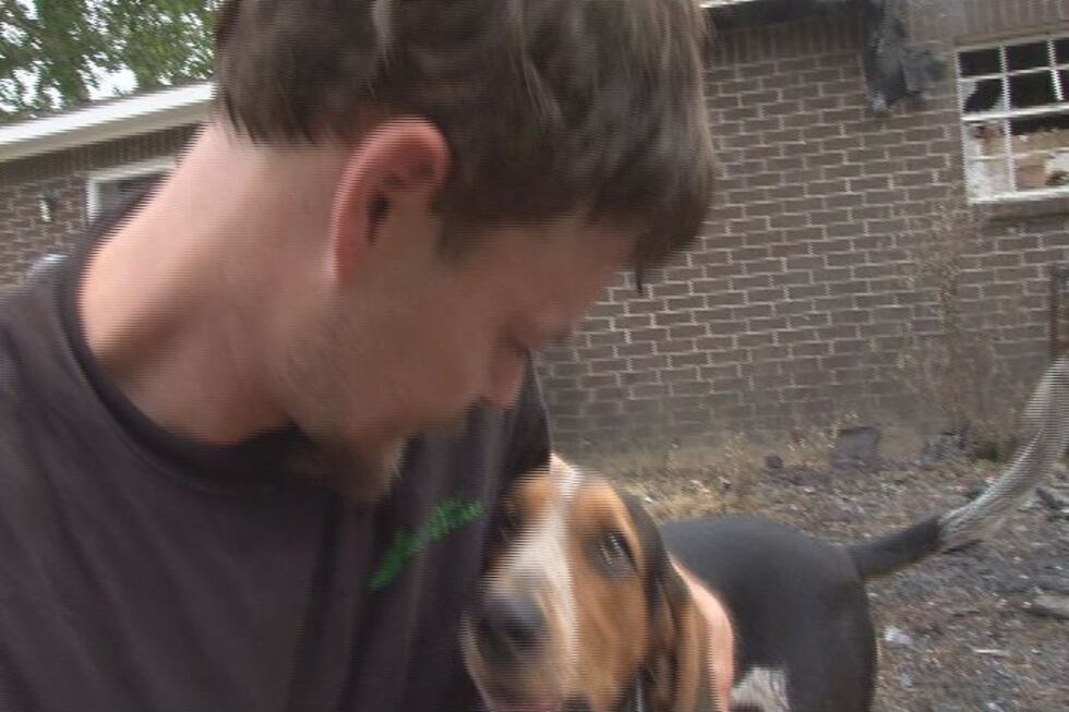 Justin Fast holds Danny, the dog that saved him from a house fire