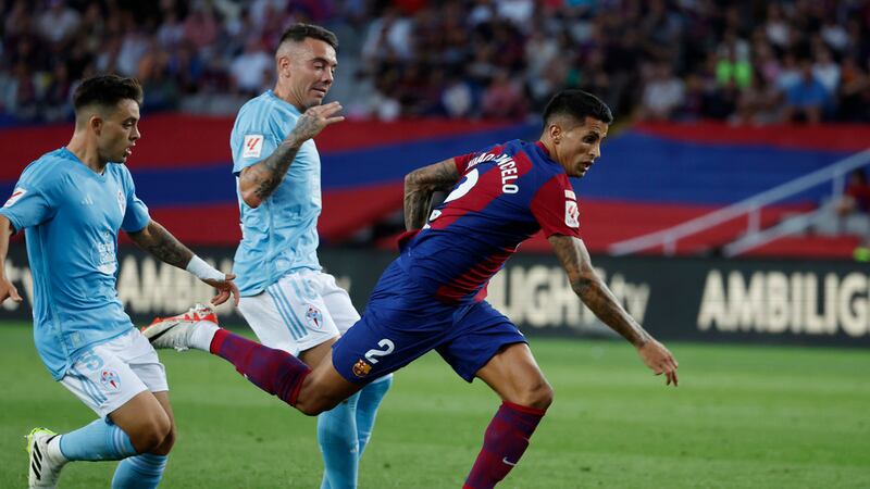 Barcelona's Joao Cancelo, right, is challenged by Celta's Iago Aspas, centre, during a Spanish...