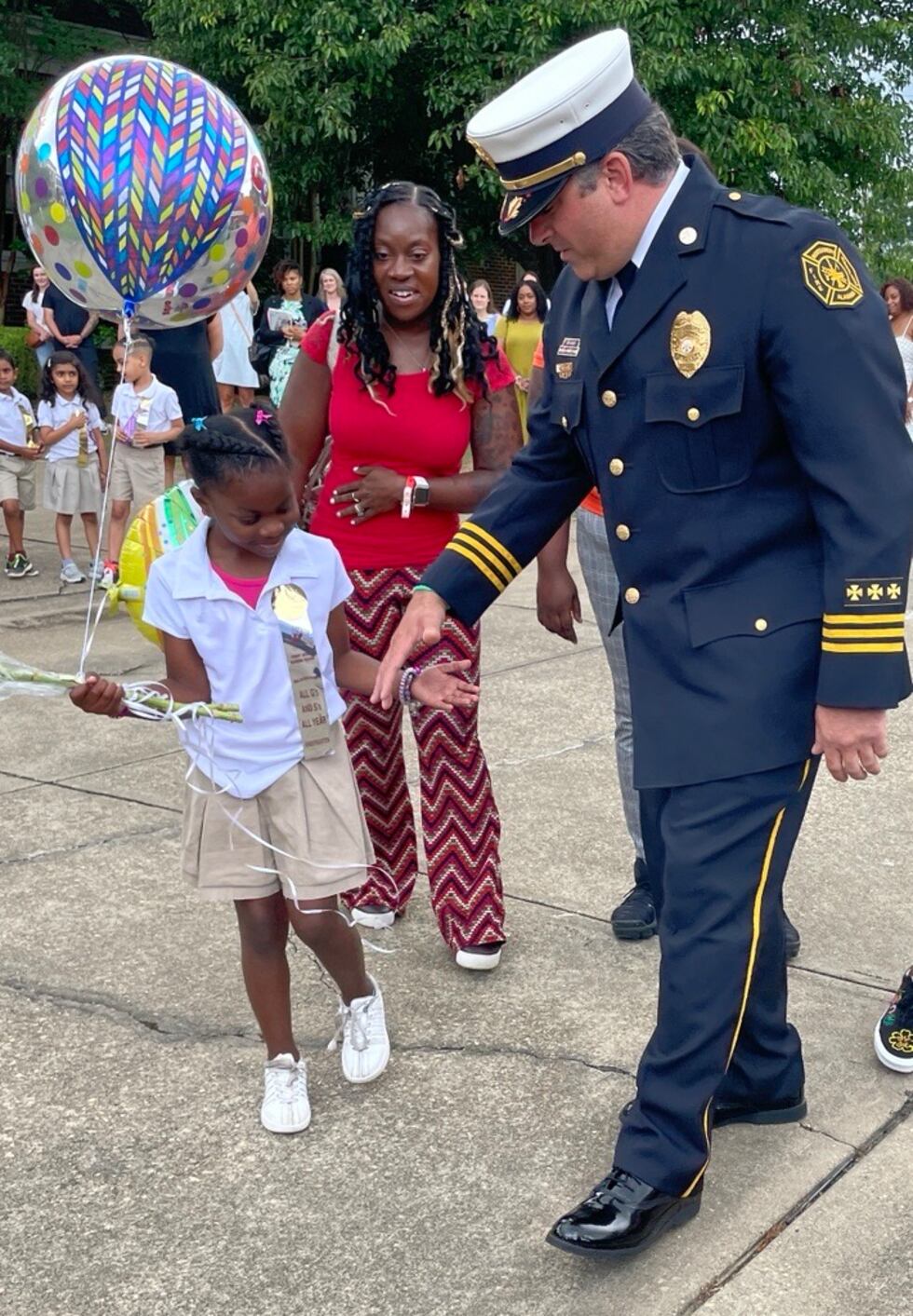 Chief of Special Operations Sam Castanza walks with Dynasti Hartman during her kindergarten...