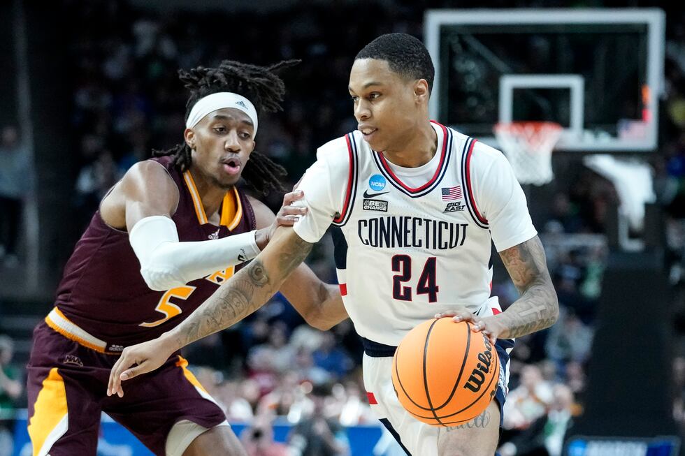 FILE - Connecticut's Jordan Hawkins (24) drives against Iona's Daniss Jenkins (5) in the...