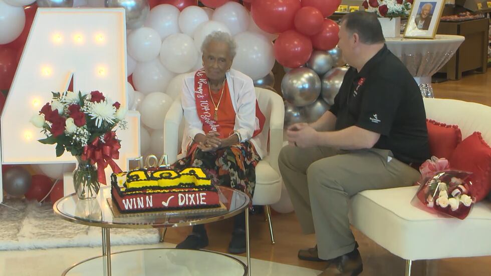 Ms. Romay Davis sits in her chair of honor at the local Winn-Dixie where she works with a...